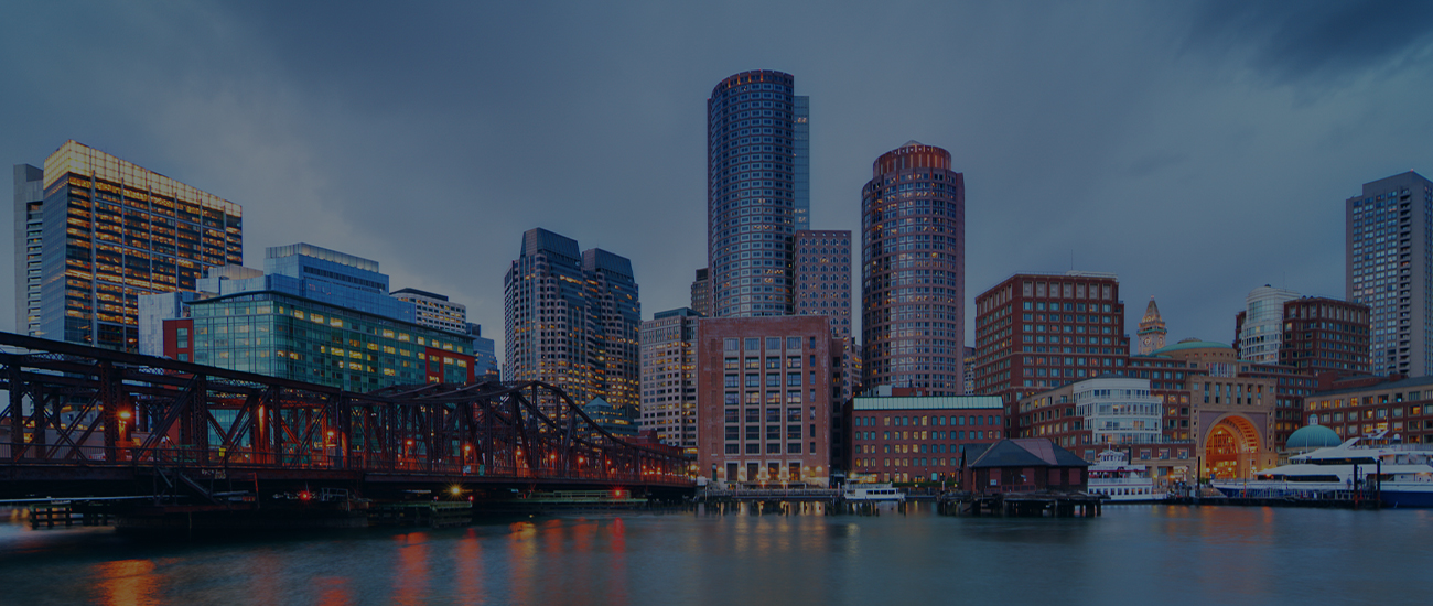 Twilight cityscape with high-rise buildings and a steel bridge.